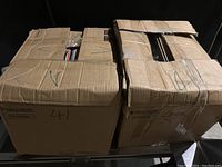 Two large cardboard boxes labeled 41 and 42, sealed with tape, containing vinyl records tightly packed inside.