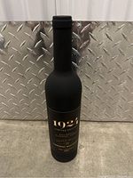 Closed black bottle-shaped case with label 1921 Limited Edition Cabernet Sauvignon.