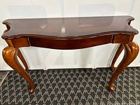 Front angle view showing curved cabriole legs and overall table shape
