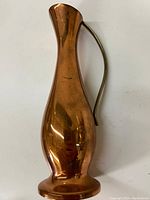 Full view of the copper pitcher showing its overall shape and handle.