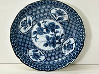 Top-down image of the round porcelain plate with blue floral and geometric patterns on white background.
