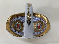 Top view of the porcelain candy dish showing gold plated scalloped rim, blue lattice interior pattern, floral medallions, and white handle with gold leaf accents.