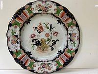 Full view of the 19th century English decorative ceramic plate, showing the floral motif and ornate border.