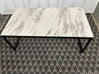 Top view of coffee table showing marble-effect rectangular top and black metal frame base.