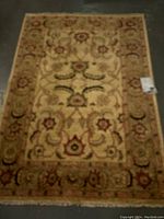 Full top view of the rectangular carpet showing the central floral design and wide border.