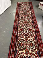 Full length view of runner on concrete floor showing medallion and floral border