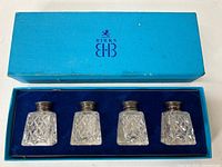 Top down photo showing four crystal containers with metal caps in original blue Birks box with velvet insert.