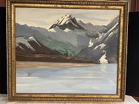 Front view of framed painting showing Western Canada mountains and lake scene, signed by artist Simord, 1979.