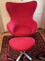 Front view of red egg chair and ottoman on patterned rug