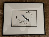 Framed art print featuring a stylized bird with black, blue, and white colors, signed and dated by Clemence Wescoupe.
