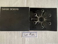 Sputnik-shaped candle holder with multiple arms for candles, metallic finish, beside original black Dansk Designs box with 'DANSK DESIGNS' label.