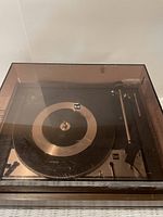 Top view of Dual 1214 turntable showing platter, tonearm, and Dual logo under smoked dust cover