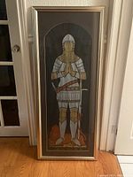 Full view of the framed medieval knight etching against a doorway.