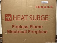 Original boxed Heat Surge Fireless Flame Electrical Fireplace showing large printed box label indicating brand and model.