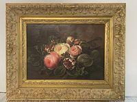 Frontal view of the floral painting in an ornate gold frame showing the full floral bouquet and frame design.