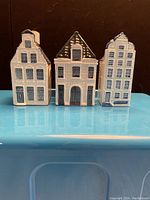 Front view of the three KLM ceramic houses showing their distinctive blue and white hand-painted Dutch architectural designs.