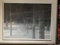 Front view of framed print showing snow-covered forest scene with multiple tree trunks