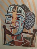 Close-up of the Picasso print 'Femme a la Resille' showing cubist-style female portrait with patterned hair and colorful geometric shapes on face.