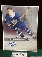 Photo of signed 8x10 color photo showing Dave Keon skating in Toronto Maple Leafs uniform with inscription in blue ink.