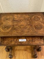 Photo of top and tier of wood table with distinctive wood grain and a label showing lot number.