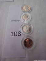 Four 1988 US proof coins, penny, nickel, dime, and quarter, displayed vertically in round plastic cases on a white background with MaxSold lot number card.