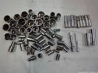Photo showing a spread of over 50 assorted Craftsmen sockets including multiple sizes and a few extensions