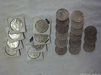Overview of 23 Mexican coins including coins in holders and loose coins on a cloth surface.