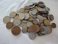 General view of the mixed pile of coins showing various sizes, metals, and designs