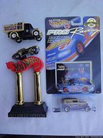 Collection of five diecast and Hot Wheels vehicles including boxed and loose items with stands