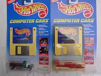 Two Hot Wheels computer cars sets still in original packaging with floppy disks and cars visible.