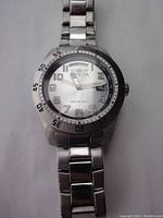 Front view of Invicta wristwatch showing silver dial, Arabic numerals, and metal bracelet.