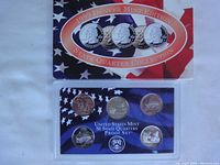 Image of the 1999 Denver Mint Washington State quarters set in aftermarket holder and 2004 US Mint proof set in original package