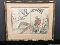Frontal view of the framed woodblock print showing two pheasants perched under peach blossom branches within bamboo-style gold frame.