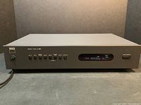 Full front view of NAD Stereo Tuner C 440 in powered off state on dark background, showing all buttons and the brand logo on the left.