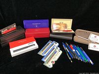 Photo of various pens with their boxes, extra cartridges, and Staedtler drafting tools