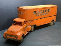 Full view of vintage orange Tonka Toys semi truck and trailer with Allied Van Lines logo on trailer side, showing condition with scuffs and rust.