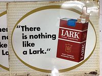 Single tin sign showing full graphic: slogan, gold border, red Lark pack