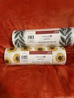 Photo of two new Celebrate It mesh ribbon rolls: one with autumn leaves design, one with sunflowers, both sized 9.5 by 10 yards.