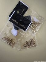 Photo showing three gold plated chain-link bracelets in original plastic packaging with black cards labeled 'Fashion Jewelry'.