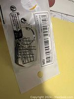Photo of silver Little Reminders key chain in original packaging showing barcode and instructions.