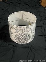 Top-side photo of the cylindrical lamp shade showing the blue floral pattern on white fabric.