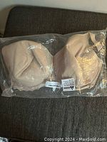 Front view of nude color bra size 36H in plastic packaging, showing molded cups and lace detail.