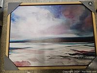 Photograph of the oil painting showing an ocean scene with clouds and waves, framed in wood with corner protectors.