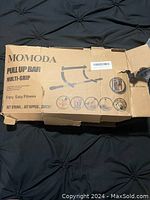 Box of Momoda multi-grip pull up bar showing branding and product image.