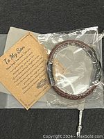 Photo of a new braided brown leather bracelet with silver magnetic clasp in plastic packaging, beside a brown cardstock sentiment card titled 'To My Son' with a heartfelt message.