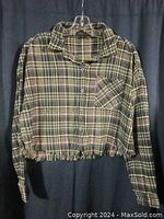 Full view of women's fleece long sleeve plaid shirt showing front with collar, button closure, chest pocket, and elastic waist detail.