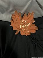 Front view of the wooden leaf shaped sign with fall theme text