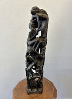Front view of the 13.5 inch tall ebony wood Makonde Tree of Life sculpture showing multiple intricately carved human figures stacked vertically.