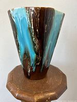 Front view of mid century Vallauris art pottery vase with turquoise glaze over brown base.