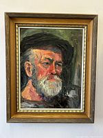 Front view of the framed portrait painting showing the bearded man in a dark hat with thick textured brush strokes.